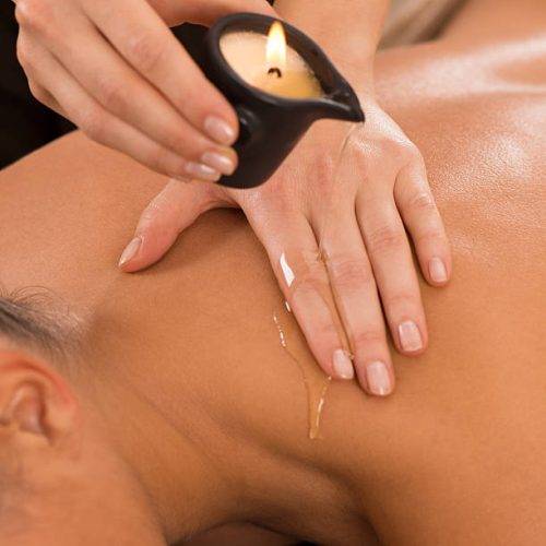 Close Up Of A Young Woman Receiving Shoulder Candle Massage At Spa.